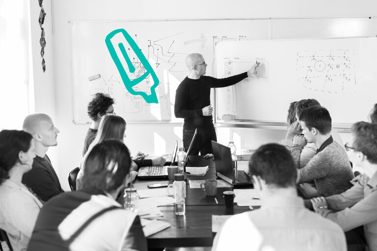 Ein Mann erklärt an einem Whiteboard